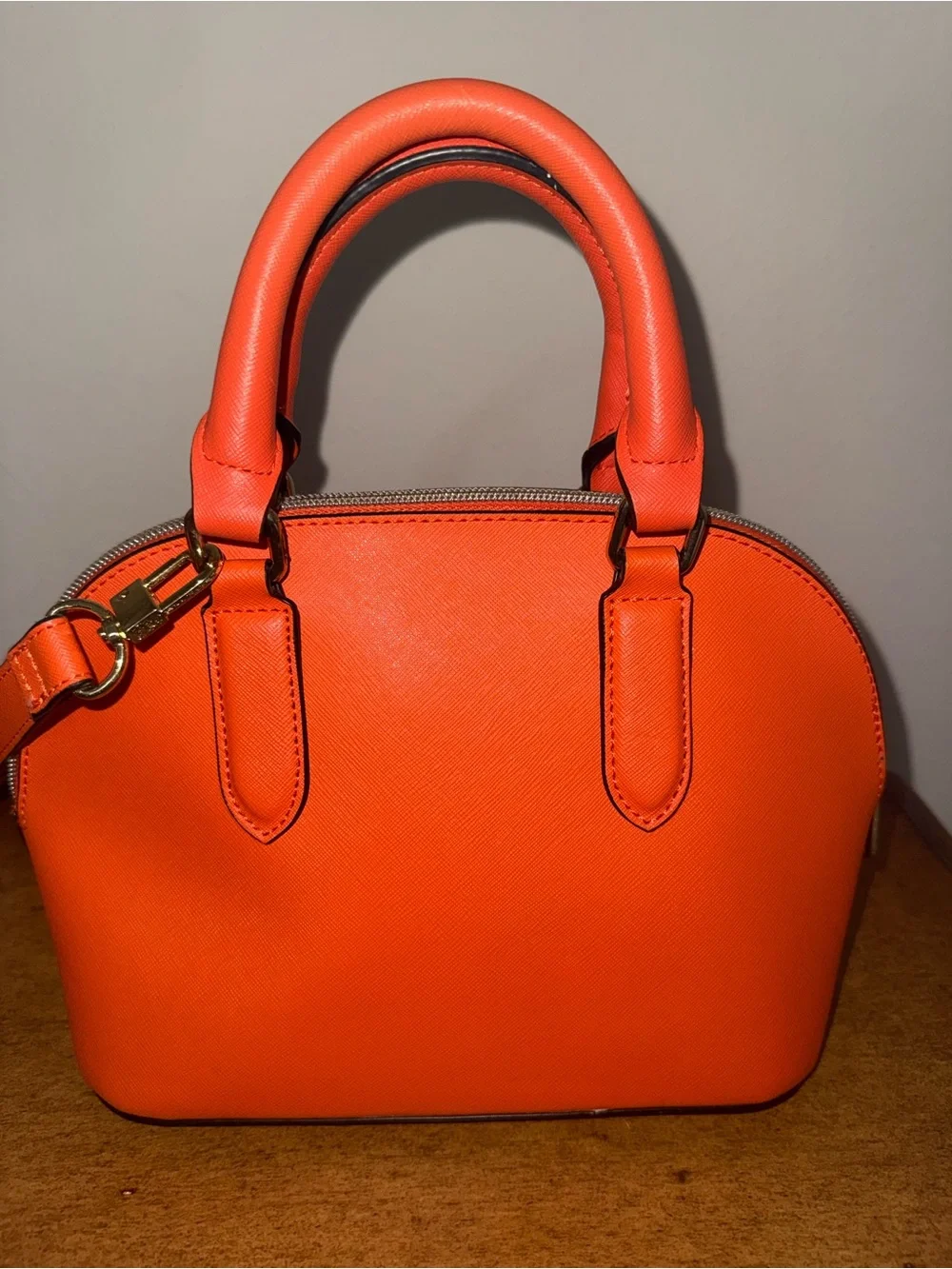 Trina Turk Dome Satchel Handbag in a vibrant, sunset orange.